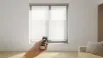 Smart motorized blinds being controlled remotely, highlighting comfort and energy efficiency