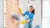 A professional cleaning a window blind, showing window blinds maintenance for home or office
