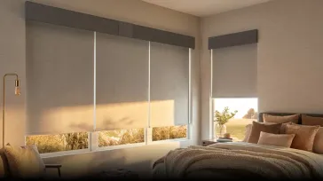 Light gray roller blinds filtering sunlight in a modern bedroom