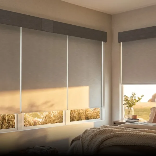 Light gray roller blinds filtering sunlight in a modern bedroom