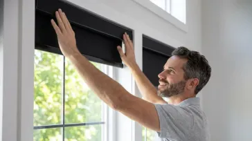 Homeowner installing roller blinds on a window with proper alignment for a secure fit
