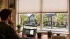 Homeowner researching a custom blinds company in Innisfil, Ontario, with a house visible through large windows fitted with blinds